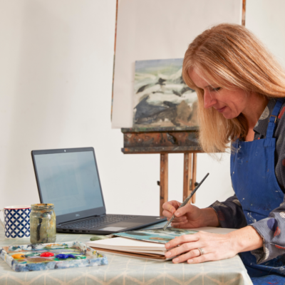 A lady painting in an online art course